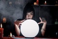 Mysterious beautiful woman fortune teller reading future on magical crystal ball