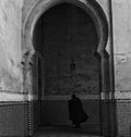 Mysterious cloaked figure leaving imperial palace, Meknes, Morocco