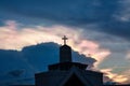 Mysterious cloud iridescence phenomenon glowing over christian church in the evening