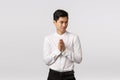 Mysterious and devious young good-looking asian businessman in white shirt, pants, rub hands and squinting sly, have