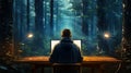 Mysterious environmental hacktivist sitts at computer at desk amidst forest Royalty Free Stock Photo