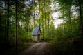 A mysterious fairytale chapel next to a gravel path - a small church or religious shrine next to a hiking trail