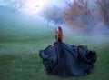 Mysterious girl with red hair runs from forest in gorgeous lace royal dress with flying light long train, lady in green Royalty Free Stock Photo