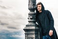 Mysterious and handsome young man model with hoody. Cloudy sky