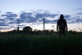 A mysterious hooded man looking at the sunset in a field of Buttercups. On a spring evening