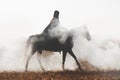 A mysterious horseman on a horse walks through the thick smoke