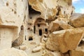 Hidden among stone boulders, the entrance to the ancient cave temple in the mountain valley of Cappadocia