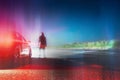 A mysterious lone figure next to a car, parked on the side of the road, on a summers night. Overlayered with a neon, retro, vapor