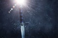 mysterious and magical photo of silver sword over gothic snowy black background. Medieval period concept. Royalty Free Stock Photo