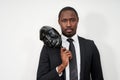 African young man wearing black suit taking off plastic mask revealing face Royalty Free Stock Photo