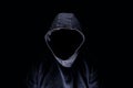 Mysterious man silhouette with darkened face, in blue hoodie on dark background Royalty Free Stock Photo