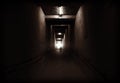 The mysterious man walks in a tunnel of darkness with a light at Royalty Free Stock Photo