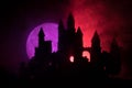 Mysterious medieval castle in a misty full moon. Abandoned gothic style old castle at night Royalty Free Stock Photo