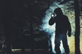 Mysterious Men with Flashlight in His Hand In Dark Foggy Forest