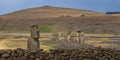 Mysterious monolithic structures with a human face are behind low wall of rocks.