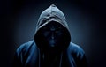 Mysterious person in hoodie wearing mask over dark background