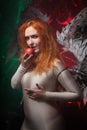 Mysterious plus size red hair girl in skincolor beige outfit with black and white big demon wings on gothic cemetery