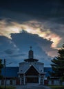 Mysterious cloud iridescence phenomenon glowing over christian church in the evening