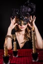 Mysterious woman in a mask near the table with alight candles Royalty Free Stock Photo