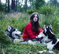 Mysterious woman in red dress with tree wolfs, forest, husky dogs mystery portrait