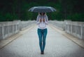 Mysterious woman with umbrella crosses a bridge Royalty Free Stock Photo