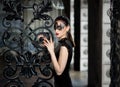 Mysterious woman in venetian carnival mask near wrought iron gate Royalty Free Stock Photo