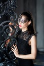 Mysterious woman in venetian carnival mask near wrought iron gate Royalty Free Stock Photo