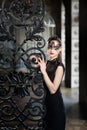 Mysterious woman in venetian carnival mask near wrought iron gate Royalty Free Stock Photo