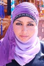 Mysterious young Jordanian woman wearing a violet veil over her hair.