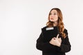 Mystery elegant woman in coat holding clipboard and looking up