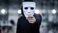 Mystery hoodie man holding white mask Royalty Free Stock Photo
