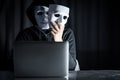 Mystery male hacker holding white mask