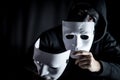 Mystery man in black mask holding white masks Royalty Free Stock Photo