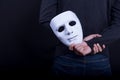 Mystery man holding white mask in the back Royalty Free Stock Photo