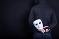 Mystery man holding white mask in the back Royalty Free Stock Photo