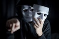 Mystery man pointing and holding white mask Royalty Free Stock Photo