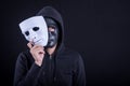 Mystery man wearing black mask holding white mask