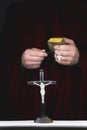 Mystery monk's hands with a cape, bible, a black rosary and cr Royalty Free Stock Photo