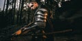 Mystery scarface knight in armor with sword and crossbow in the forest Royalty Free Stock Photo