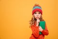 Mystery Young girl in sweater and hat holding book