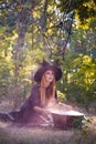 The forest enigmatic witch in the green wood outdoors.