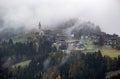 Mystic cloudy and foggy autumn alpine mountain village slopes scene. Austrian Lienzer Dolomiten Alps