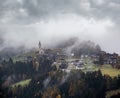 Mystic cloudy and foggy autumn alpine mountain village slopes scene. Austrian Lienzer Dolomiten Alps Royalty Free Stock Photo