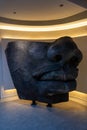 Mystic Colossus An imposing stone head sculpture of mythical origin, with dramatic lighting that accentuates its mysterious and