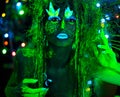 Mystic green dryad in UV fluor black light with Glowing trees on background