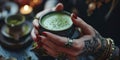 Mystic Matcha Ritual: Woman& x27;s Hands, Adorned with Tattoos and Rings, Cradle a Cup of Antioxidant-Rich Latte