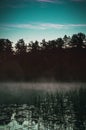 Mystic morning fog on forest lake.