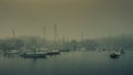 Recreational sailboats moored in a harbor on a foggy summer day Royalty Free Stock Photo