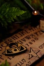 Mystic ritual with Ouija and candles. Devil`s board concept, black magic or fortune telling rite with occult and esoteric symbols Royalty Free Stock Photo