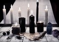 Mystic still life with black candles and pentagram on paper